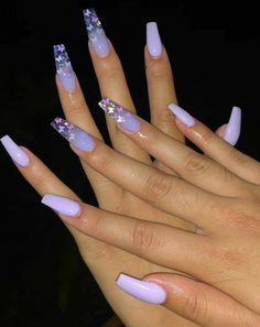 the woman is holding her hands with purple nails