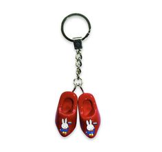 a pair of red shoes hanging from a metal keychain