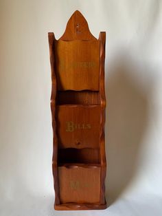 a wooden book shelf with three compartments and numbers on the front, sitting against a white background