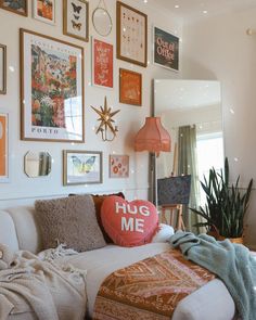 a living room filled with lots of pictures on the wall and furniture in front of it