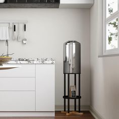 a kitchen with white cupboards and counter tops next to a window in an open floor plan