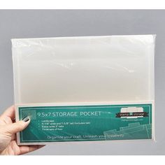 someone holding up a package of white storage pockets for their home or office space