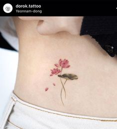 a woman's stomach with a flower tattoo on it