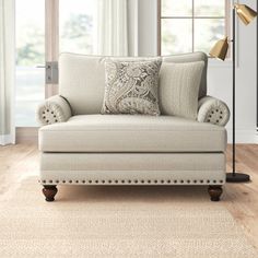 a living room scene with focus on the arm chair and floor lamp in the background