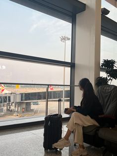 a woman sitting in an airport waiting for her luggage to be picked off the plane