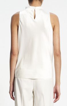 This Theory Women's cowl neck sleeveless top is the perfect blend of elegance and style. Crafted in luxurious ivory fabric, it features a cowl neck and keyhole detail for added visual interest. Wear this flattering top for a work-friendly look or to add a touch of sophistication for weekend outings. Details High cowl neck Sleeveless N0809511C05 Material 86% acetate 14% polyester Care Dry clean only Elegant White Viscose Top, Chic Cream Silk Top, Elegant Fitted Sleeveless Top, Chic Cream Tank Top, Elegant Fitted Camisole For Spring, Elegant Viscose Camisole Tank Top, Elegant Sleeveless Viscose Top, White Silk Camisole For Spring, Elegant Fitted Sleeveless Camisole