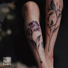 a woman's legs with tattoos and flowers on them