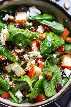 spinach salad with cranberries, pine nuts and feta cheese in a bowl