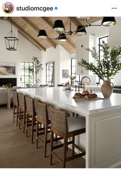 an instagramted photo of a kitchen with chairs and counter tops in the center