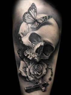 a skull with a rose and butterfly on it's head is shown in this tattoo design