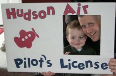 a man and his son are holding up a sign