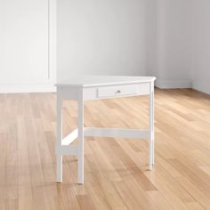 a white desk sitting on top of a hard wood floor next to a wall and window