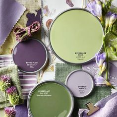 three different shades of green paint with purple flowers on the side and one in the middle