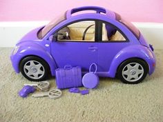 a purple toy car sitting on top of a carpeted floor