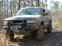 an off road truck is parked in the woods