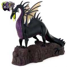 a figurine of a dragon on a rock with a flower in it's mouth