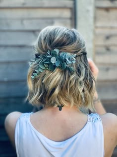 the back of a woman's head wearing a hair piece with leaves on it