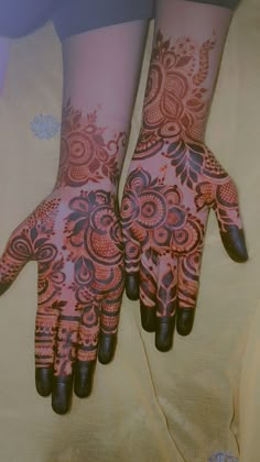 two hands with henna designs on them