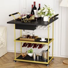 a bar cart with wine glasses, bottles and other items on it in a living room