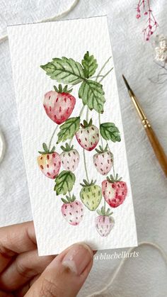 a person holding up a card with strawberries on it