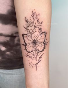 a woman's arm with a butterfly and flowers tattoo on the left inner arm