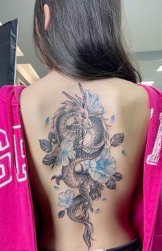 a woman with a dragon tattoo on her back