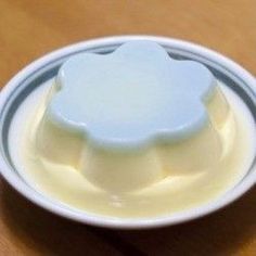 a white bowl filled with yogurt on top of a wooden table