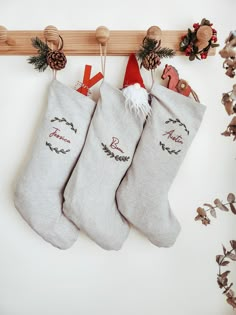 two christmas stockings hanging from a wooden rail