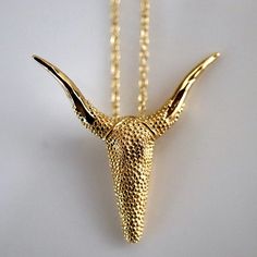 a gold necklace with an animal's head on it