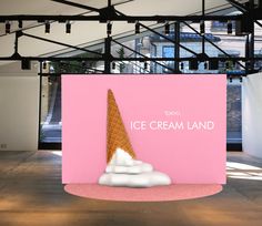 an ice cream land sign in front of a pink background with white clouds on it