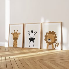 three framed pictures of animals are on the floor in front of a white wall and wooden floors