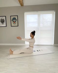 a woman is sitting on the floor doing yoga