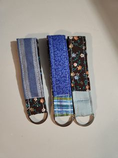 three pieces of fabric are tied together on a white table top, one is blue and the other is brown