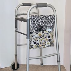 an elderly walker with a quilted bag on it's handlebars next to a wall