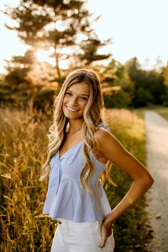 a beautiful young woman standing in the middle of a field