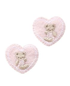 two pink heart shaped patches with a teddy bear on them