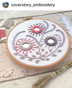 an embroidery project with flowers and feathers on it