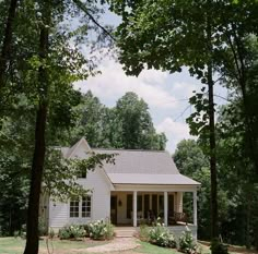 a white house surrounded by trees and grass