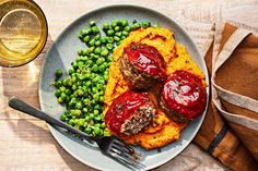 a plate with meatballs, mashed potatoes and peas