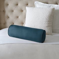 a pillow on top of a bed next to pillows