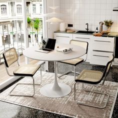 a white table and chairs in a small room with an open door to the outside