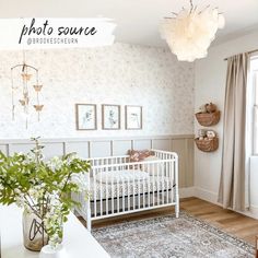 a baby's room with a white crib in the corner and pictures on the wall