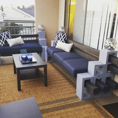 a living room with blue couches and coffee table on top of carpeted floor