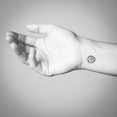 a person's arm with a small tattoo on the left side of their wrist