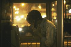 a man standing in front of a window using a phone