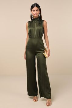 You'll feel like total royalty in the Lulus Classic Elegance Olive Green Satin Sleeveless Mock Neck Jumpsuit! Luxe woven satin shapes this chic jumpsuit that has a mock neckline and a sleeveless bodice with gathered fabric detailing. Fitted waist tops wide legs that end at ankle-length hems. Keyhole opening and double button closure at back. Hidden back zipper/clasp. Fit: This garment fits true to size. Length: Floor length. Size medium measures 61.25" from shoulder to hem. Inseam: 32.25 Front R Winter Wedding Guest Jumpsuit, Jumpsuits For Wedding Guest, Sleek Sleeveless Evening Jumpsuits And Rompers, Glamorous Satin Jumpsuits And Rompers For Spring, Glamorous Spring Satin Jumpsuit, Chic Satin Jumpsuits And Rompers In Solid Color, Chic Solid Color Satin Jumpsuits And Rompers, Elegant High Neck Jumpsuit For Night Out, Elegant Fitted High Neck Jumpsuit