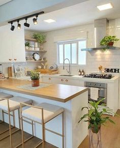 a kitchen with white cabinets and wooden counter tops next to an island in the middle