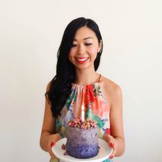 a woman holding a plate with a cake on it