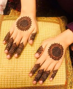 two hands with henna tattoos on them