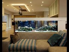 a living room filled with furniture and an aquarium in the middle of it's wall